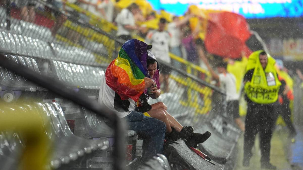 Zwei Fans verharren auf ihren Plätzen. 