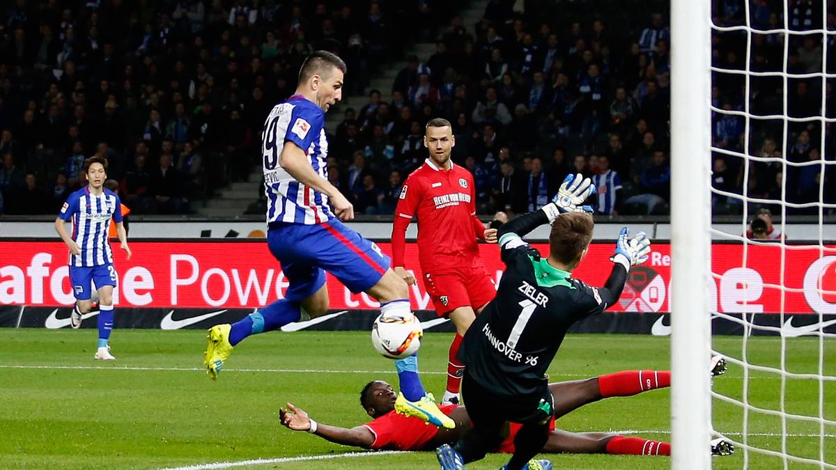 Und er erfährt, dass in der Bundesliga der kleinste Fehler unverzüglich bestraft wird. Bereits in der 3. Minute erlebt Stendel seinen ersten Gegentreffer als Bundesliga-Trainer.  Ron-Robert Zieler (r.) erwischt nur noch Hertha Stürmer Vedad Ibisevic (Mitte). Der Ball rollt ins Tor