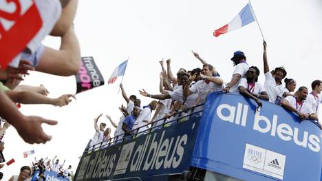 French athletes celebrate on top of a do