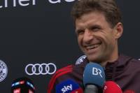 Die neuen Autos des FC Bayern kommen überraschend schlicht daher. Thomas Müller scherzt mit einem Reporter über die Farbe seines Autos.