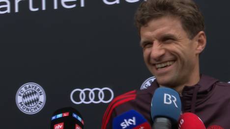 Die neuen Autos des FC Bayern kommen überraschend schlicht daher. Thomas Müller scherzt mit einem Reporter über die Farbe seines Autos.