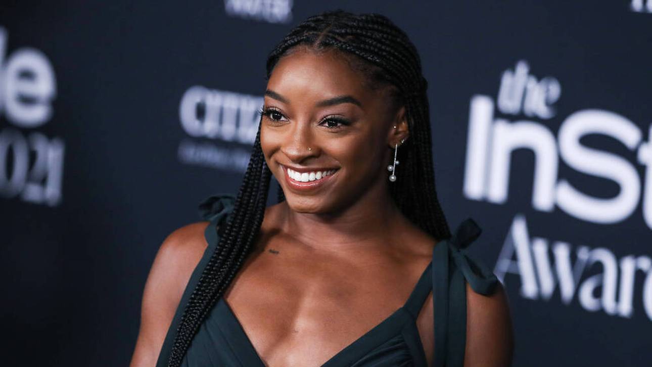 Stewardess bietet Biles Malbuch an