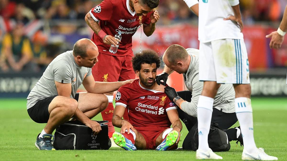 Salah bleibt mit schmerzverzerrtem Gesicht liegen und hält sich die Schulter. Nach kurzer Behandlung kann er aber weitermachen