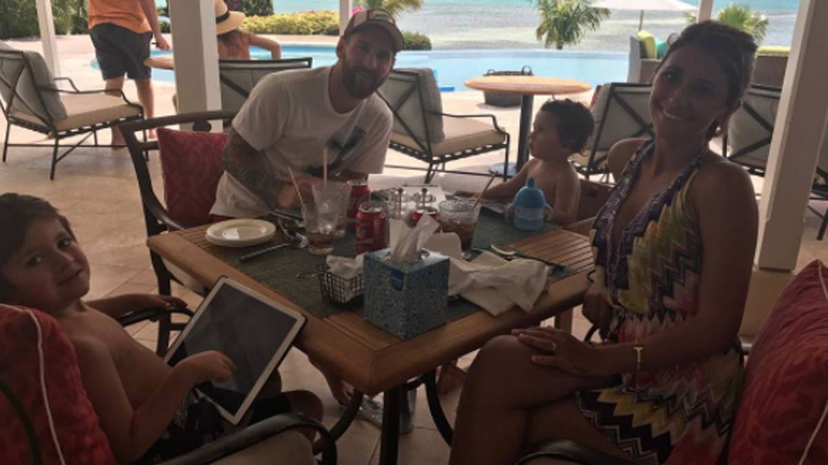Leo Messi weiß, wie man sich im Urlaub erholt. Palmen, weißer Strand und azurblaues Meer im Hintegrund, ein kleiner Snack zwischendrin und die gut gelaunte Familie am Tisch