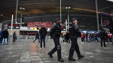 Französische Polizisten patroullieren vor einem Stadion.