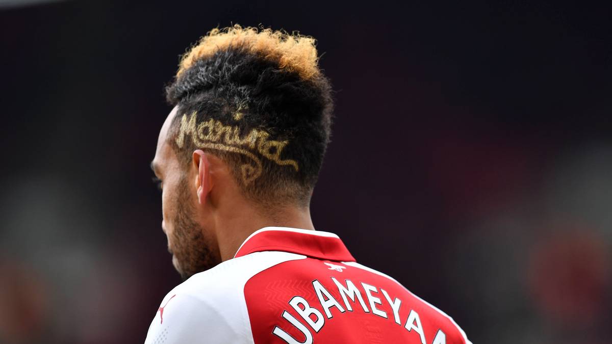 Pierre-Emerick Aubameyang transportiert im Spiel gegen Stoke City mit seiner Frisur eine ganz besondere Botschaft. Mit dem einrasierten "Marina" gedenkt er seiner kürzlich verstorbenen Oma. "Es ist der Name meiner Großmutter", erklärt der Arsenal-Star nach dem Spiel. "Sie ist letzte Woche verstorben und das ist meine Widmung an sie"