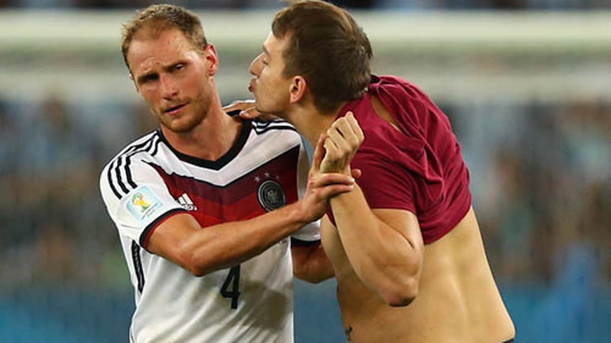 Trotz unzähliger Sicherheitskräfte im Stadion schafft es ein Flitzer auf den Rasen und hat es auf Höwedes abgesehen. Der ist nur angewidert
                  