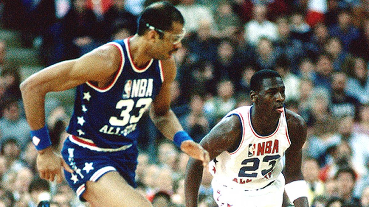 Als Rookie wird der Jungspund sofort als Starter zum All-Star Game eingeladen. Was heute fast schon normal ist, schlägt 1985 hohe Wellen. Die Routiniers der Eastern Conference um Detroits Isiah Thomas zeigen ihm die kalte Schulter. So muss es Michael allein mit Kareem Abdul-Jabbar (l.) aufnehmen.
