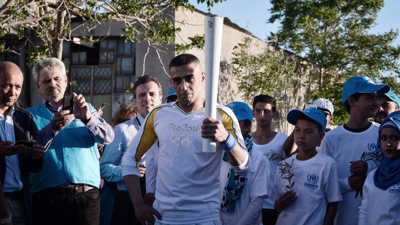 Flüchtling trägt Olympisches Feuer