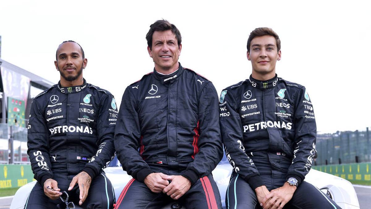 Lewis Hamilton posiert 2022 neben Mercedes-Teamchef Toto Wolff und Teamkollege George Russell