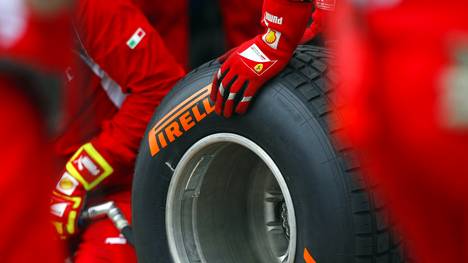 Ferrari technicians handle a Pirelli wet