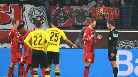 Referee Robert Hartmann zeigt Leverkusens Wendell (Zweiter von links) die Rote Karte