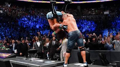 John Cena (r.) beförderte AJ Styles zwar durch einen Kommentatorentisch - zum Sieg reichte es jedoch nicht