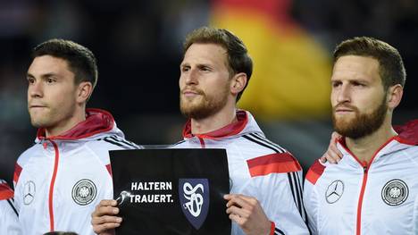Das DFB-Team um Benedikt Höwedes (M.) gedenkt der Opfer des Flugzeugabsturzes