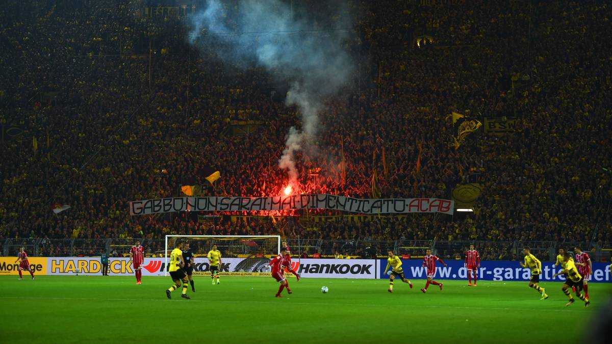 Die Dortmunder Fans brennen auf der Südtribüne eine Leuchtrakete ab u
