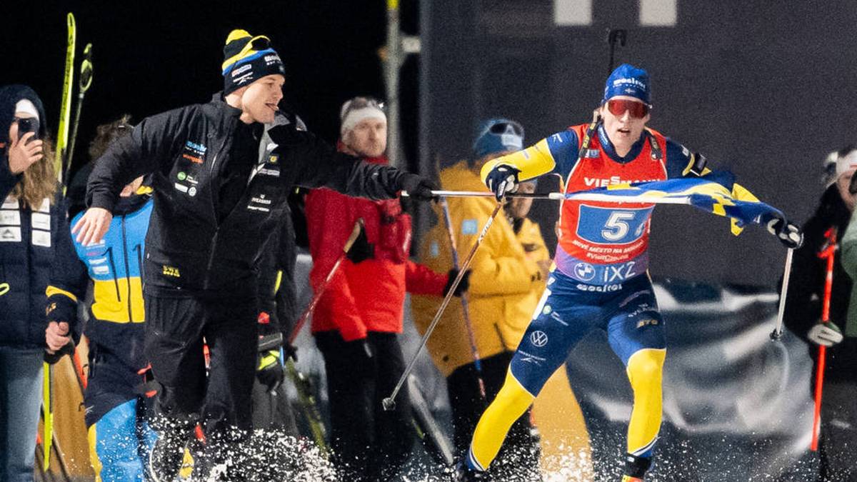 Trainer Johannes Lukas (l.) reichte Staffel-Schlussläufer Sebastian Samuelsson beim WM-Gold für Schweden die Flagge
