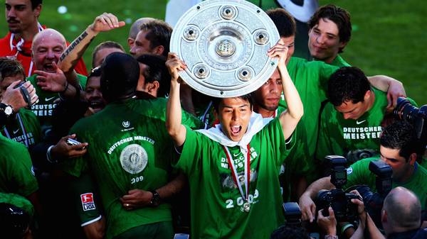 WOLFSBURG, GERMANY - MAY 23:  Makoto Hasebe of Wolfsburg celebrates the German Championship with the trophy after his Bundesliga match between VfL Wolfsburg and SV Werder Bremen at the Volkswagen Arena on May 23, 2009 in Wolfsburg, Germany. Wolfsburg won its first German Championship ever. (Photo by Vladimir Rys/Bongarts/Getty Images)