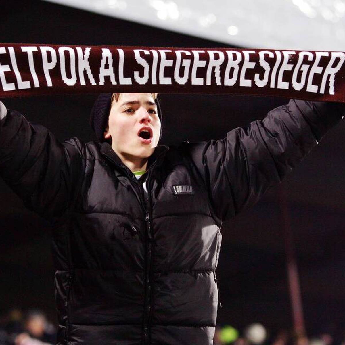 Ein St. Pauli Fan präsentiert stolz einen Schal mit der Aufschrift Weltpokalsiegerbesieger