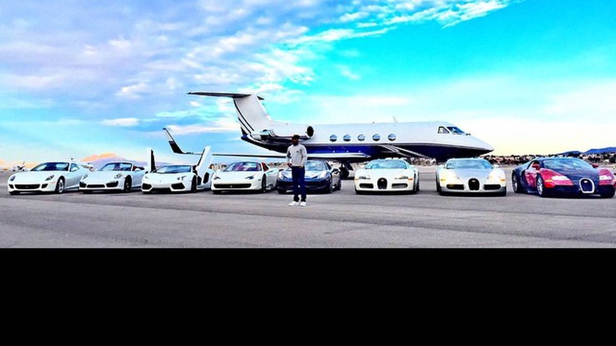 Zusammen mit seinem Privatjet präsentiert er seine eigene Flotte auf dem Rollfeld eines Flughafens: Die drei Neuerwerbungen, drei Ferrari, ein Lamborghini und ein Porsche im Gesamtwert von etwa 8 Millionen Dollar