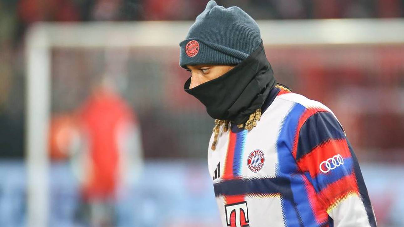 Sacha Boey mit Mütze und Schaltuch beim Aufwärmen