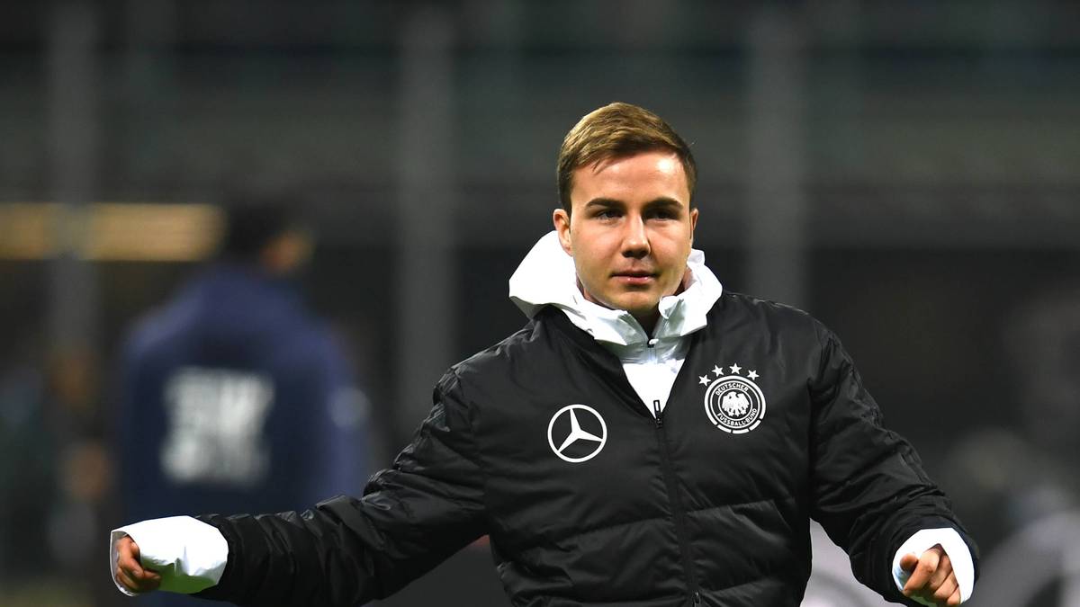 Mario Götze hat ein interessantes Kleidungsstück an, um sich vor der Kälte zu schützen. Seine Daunenjacke ist ein XXL-Mantel, erinnert aber ein bisschen an einen Schlafsack