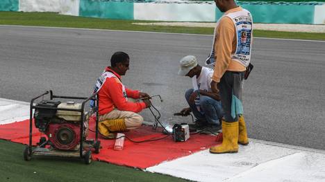 Streckenarbeiter reparieren den Gullideckel, der Romain Grosjean im Freien Training der Formel 1 in Malaysia zum Verhängnis wurde