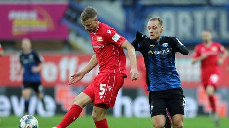PADERBORN, GERMANY - DECEMBER 14: Marvin Friedrich of 1. FC Union Berlin shoots while challenged by Ben Zolinski of SC Paderborn 07 during the Bundesliga match between SC Paderborn 07 and 1. FC Union Berlin at Benteler Arena on December 14, 2019 in Paderborn, Germany. (Photo by Christof Koepsel/Bongarts/Getty Images)