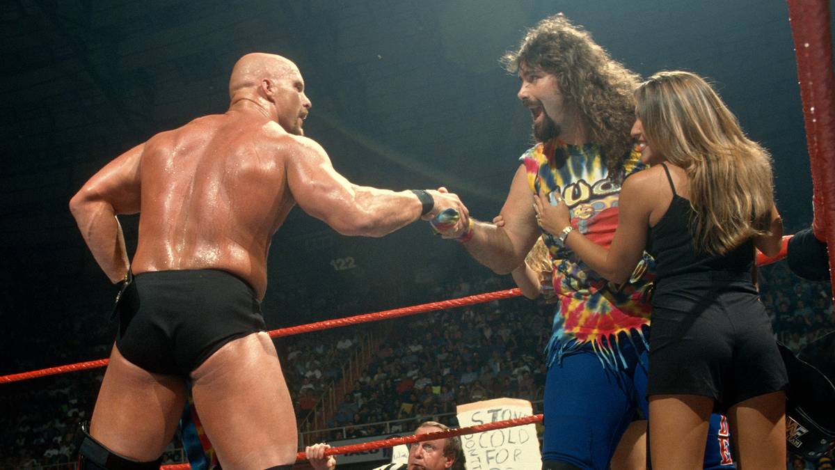 14. JULI 1997 - Foleys Alter Ego dagegen ist ein Netter: Als "Dude Love" schließt er sich mit dem ebenfalls zum Publikum gewordenen Steve Austin zusammen und gewinnt mit ihm gemeinsam die Tag Team Titel