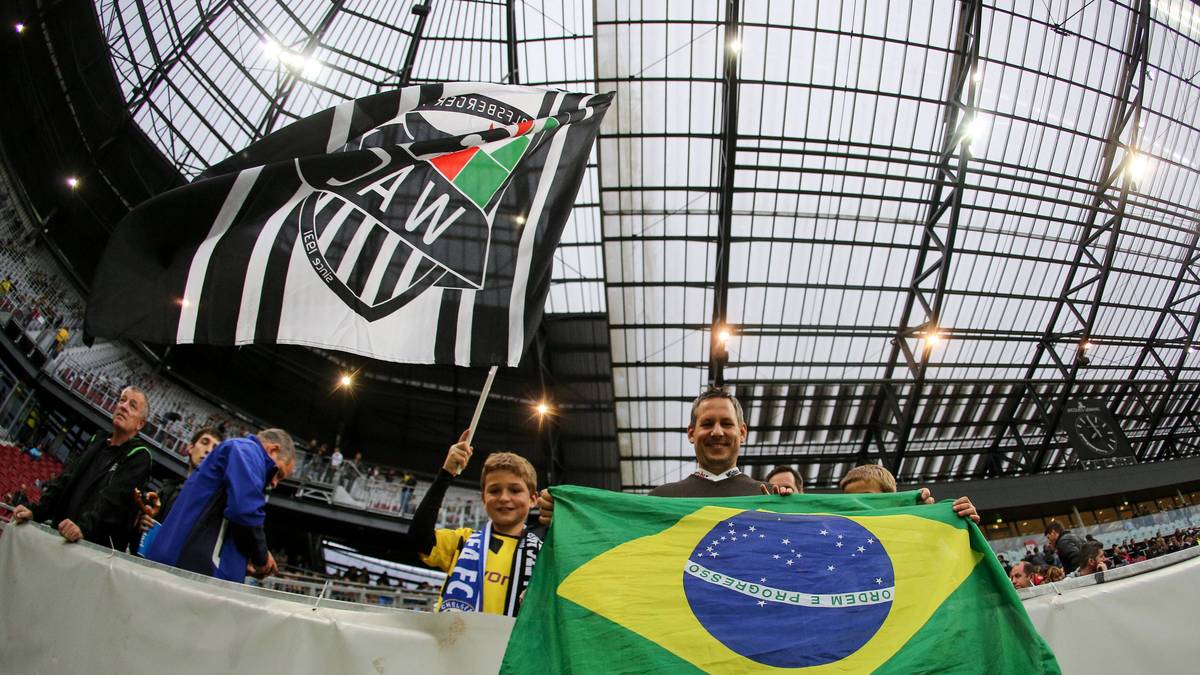 Die Wolfsberger Fans sind natürlich auch da und bringen eine brasilianische Fahne an - wohl für den brasilianischen Stürmer Silvio