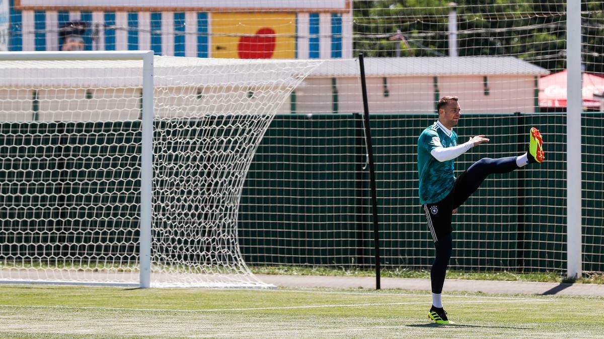Manuel Neuer wärmt sich in Sotschi auf. Im Hintergrund das Museum "Haus des Riesen"