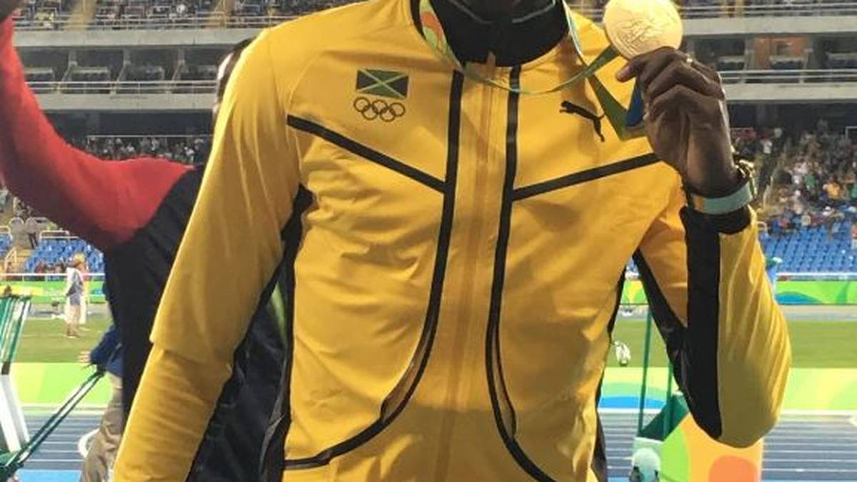 Goldjunge Usain Bolt präsentiert stolz seine Medaille nach dem dritten Sieg hintereinander über die 100 Meter bei Olympia
