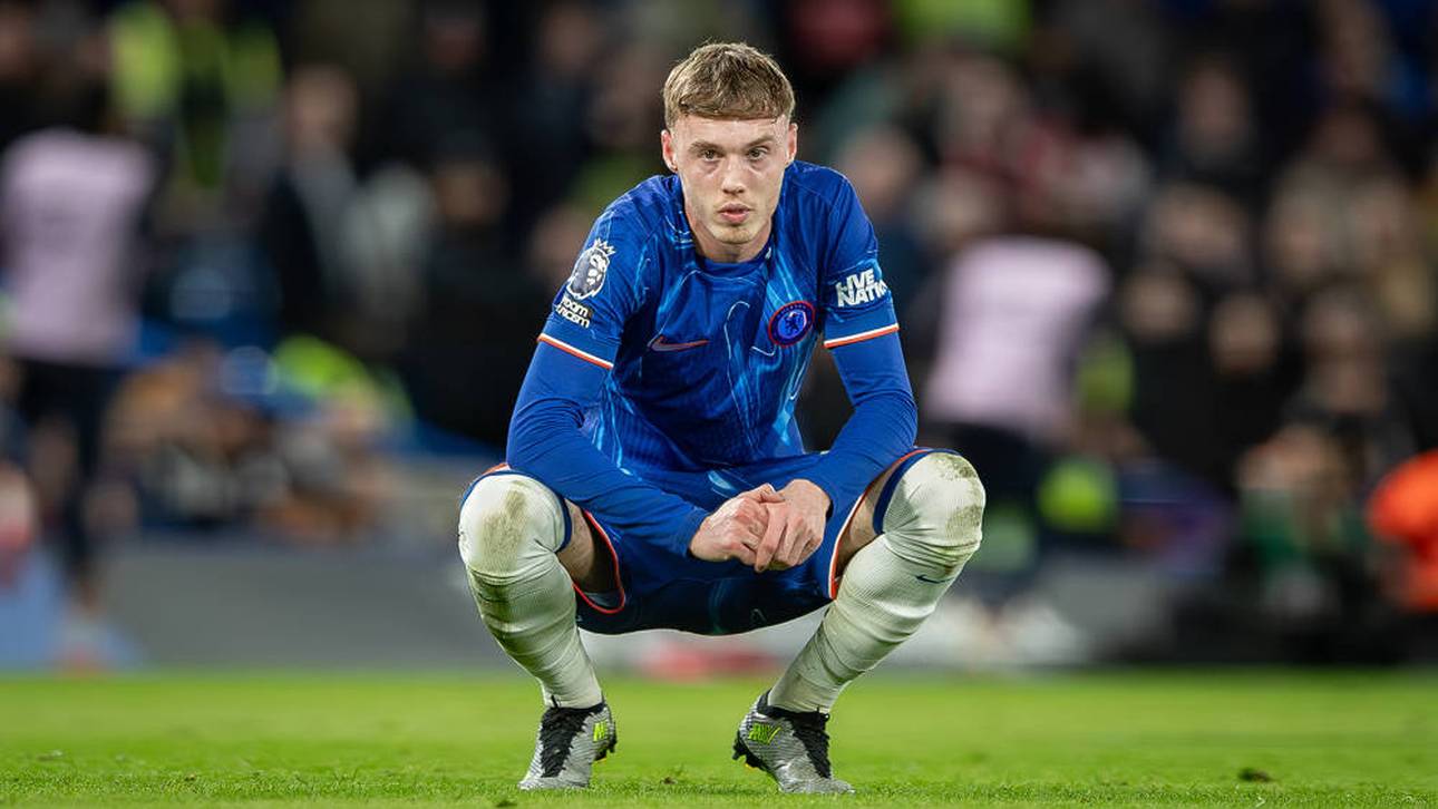 Cole Palmer verharrt nachdenklich in der Hocke auf dem Rasen der Stamford Bridge