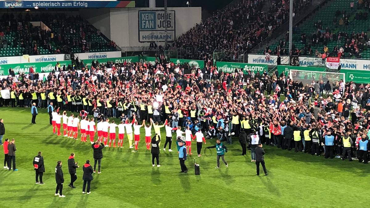 Hinter einer Ordner-Kette darf sich der gesamte mitgereiste Anhang formieren und die Spieler feiern