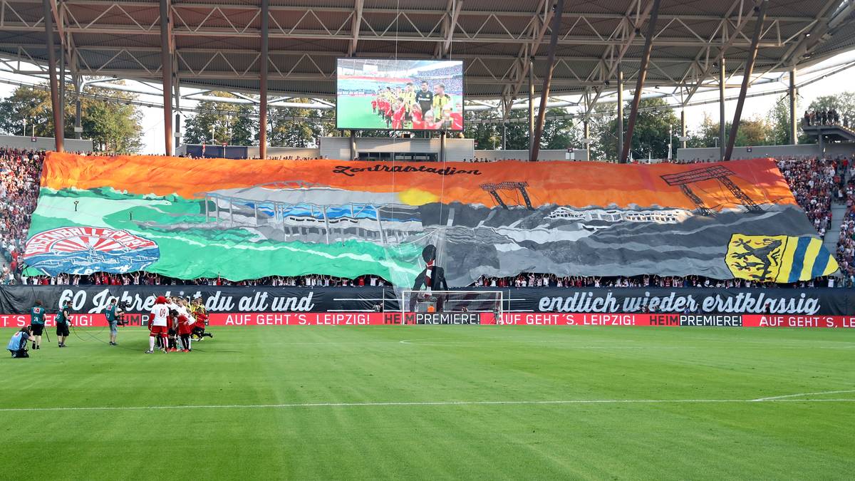 Feiertag in Leipzig! Die Fans von RB würdigen ihr Zentralstadion, das seit dem Einstieg des Investors eigentlich "Red Bull Arena" heißt. "60 Jahre bist du alt und endlich wieder erstklassig", verkündet die riesige Choreografie