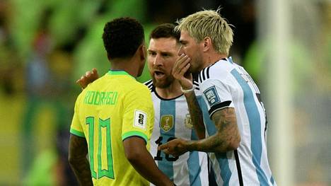 Rodrygo (in gelb) diskutiert mit Messi und De Paul