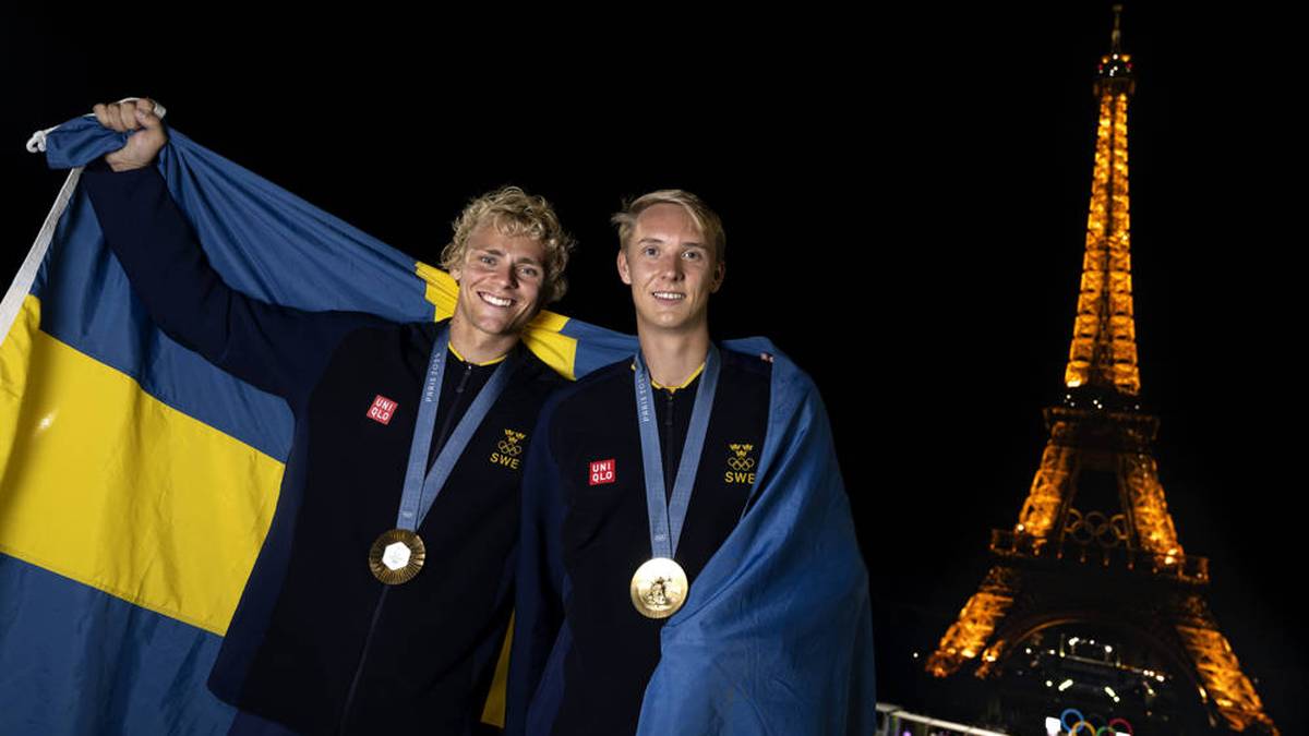 Die schwedischen Beachvolleyballer David Ahman (l.) und Jonatan Hellvig präsentieren ihre olympischen Goldmedaillen vor dem Eiffelturm 