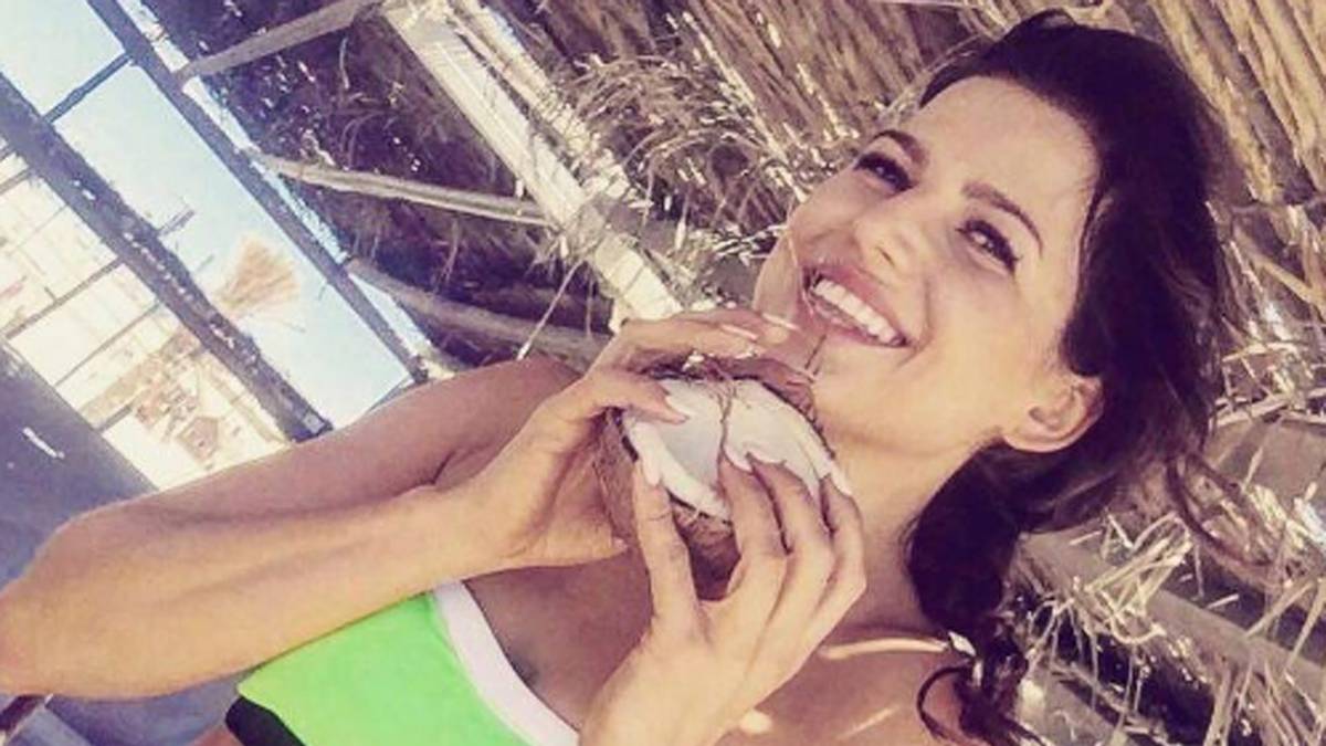 Gesunde Ernährung komplettiert den sportlichen Lebensstil. Anna genießt eine Kokosnuss