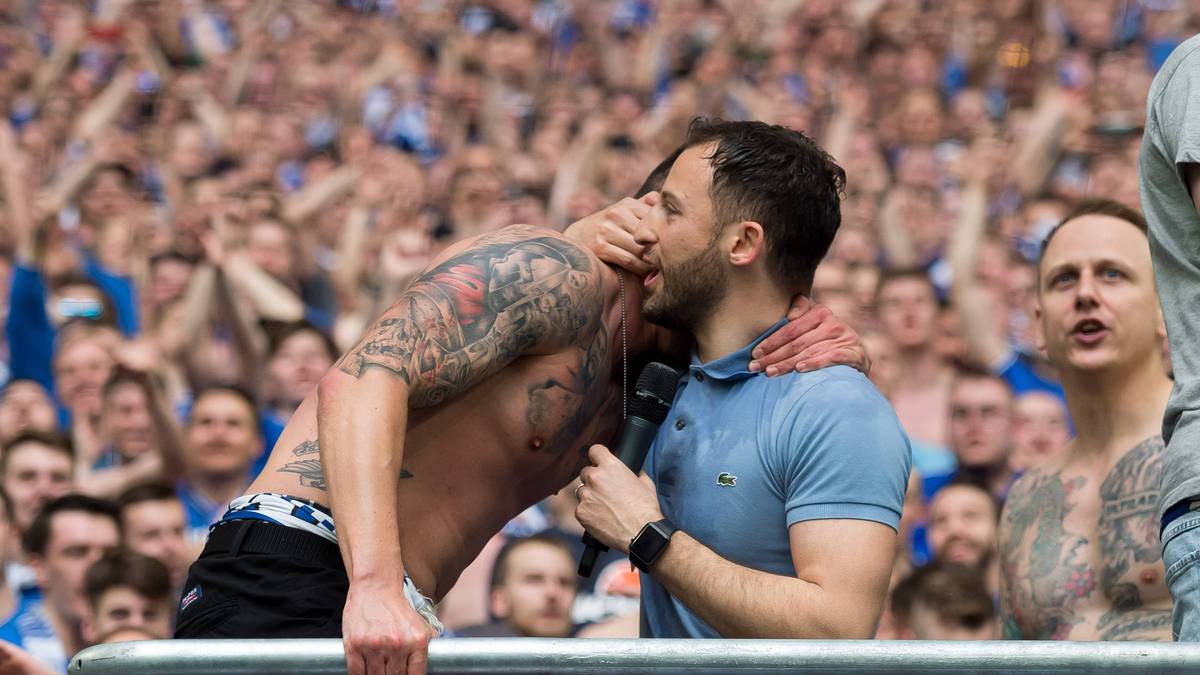 Schalke-Coach Domenico Tedesco geht nach dem Triumph in die Schalke-Kurve und lässt sich vom Capo der Ultras feiern