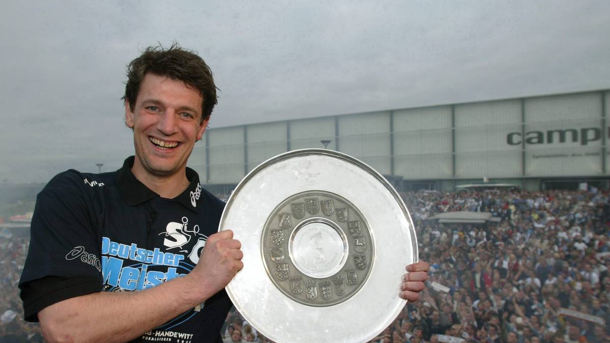 2004: Torwart-Ikone Jan Holpert präsentiert den Flensburger Anhängern die Schale. Zum ersten Mal in der Vereinsgeschichte wird die SG Meister - und wie: Flensburg (58:10) feiert den Titel, Erzrivale Kiel ist nur einen Sieg dahinter (56:12) und hat auch die um 16 Treffer bessere Tordifferenz