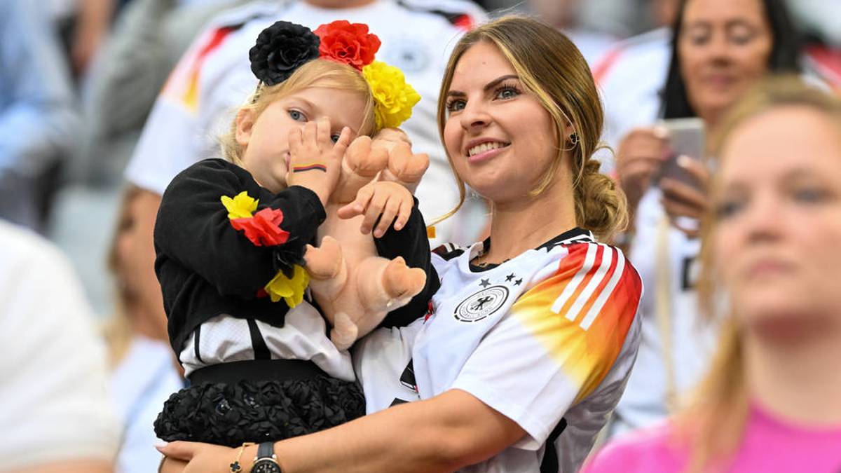 Lisa Füllkrug fiebert mit ihrer Tochter und einem Glücksschweinchen mit