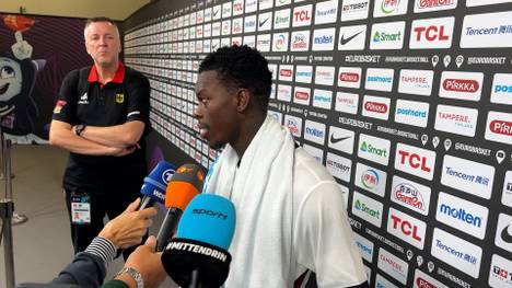 Nach rassistischen Äußerungen gegen Dennis Schröder reagieren die Fans in der Halle beim Spiel gegen Großbritannien mit unterstützenden Plakaten. Der DBB-Star bedankt sich hinterher.