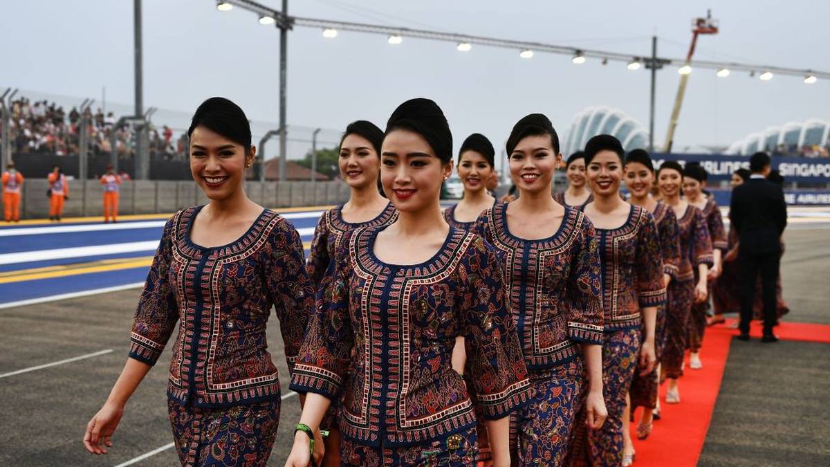 Flight attendants for Singapore Airlines take part in early festivities before the drivers' parade ahead of the start of the Formula One Singapore Grand Prix at the Marina Bay Street Circuit in Singapore on September 22, 2019. (Photo by Mohd RASFAN / AFP)        (Photo credit should read MOHD RASFAN/AFP/Getty Images)