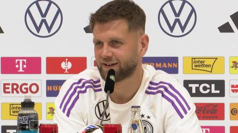 Auf einer Pressekonferenz der deutschen Fußballnationalmannschaft spricht Nationalspieler Niclas Füllkrug über seine Verbindung zum DFB-Team und die Hausdekoration seiner Familie.