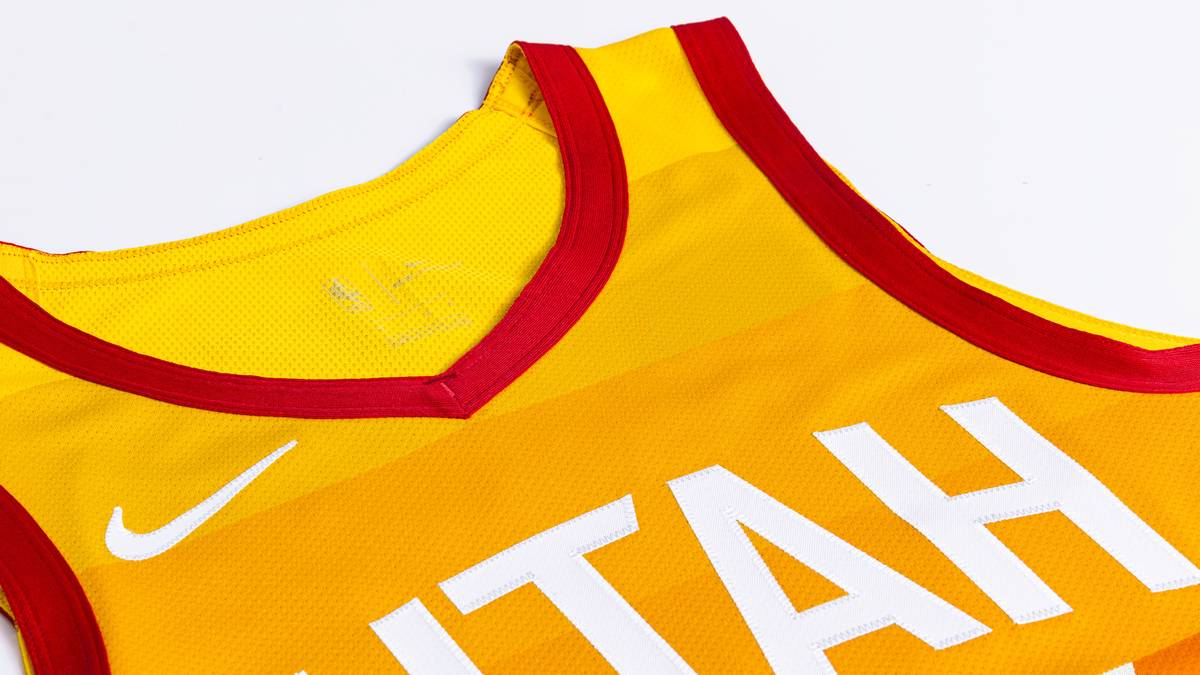 UTAH JAZZ: Die warmen Farben sind geschichtet wie die alten und atemberaubenden Felsformationen, die die natürliche Landschaft des Staates prägen. Grafische Interpretationen der I-15 und I-70 verlaufen an den Seiten und stellen die Autobahnen dar, die von Salt Lake City zu den berühmten Parks von Utah führen
