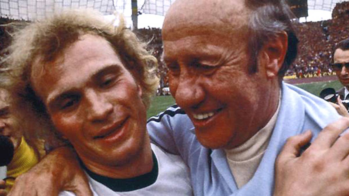 Doch damit nicht genug: Bei der Heim-WM räumt er mit Deutschland den WM-Titel ab und feiert den 2:1-Finalsieg über Erzrivale Holland mit Bundestrainer Helmut Schön (r.)