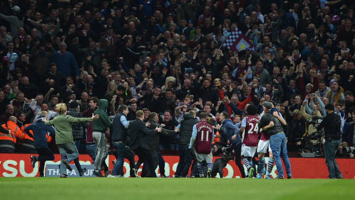 Schon unmittelbar nach dem Tor stürmt eine Reihe von Anhängern Astons auf den Platz, um das Tor zu feiern