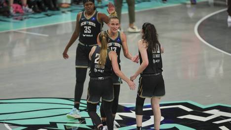 Leonie Fiebich (M., Nr. 13) feiert Sabrina Ionescu (vorne links)