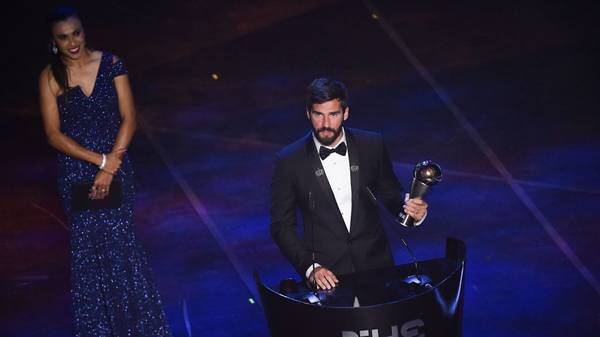 Brazil and Liverpool goalkeeper Alisson Becker speaks after winning the trophy for the Best FIFA Men's Goalkeeper of 2019 Award, presented by Brazil and Orlando Pride forward, Marta (L) during The Best FIFA Football Awards ceremony, on September 23, 2019 in Milan. (Photo by Marco Bertorello / AFP)        (Photo credit should read MARCO BERTORELLO/AFP/Getty Images)