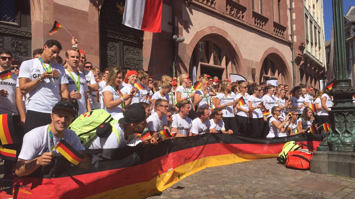 Die deutschen Olympioniken posieren vor dem Römer. Bei hochsommerlichen Temperaturen kommen sie ganz schön ins Schwitzen.  