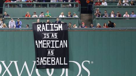 Beim Spiel der Boston Red Sox hängen vier Fans ein Banner gegen Rassismus auf